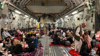 Afghan people sit inside a US military aircraft during an evacuation at the military airport in Kabul on 19 August 2021, following the Taliban’s capture of the Afghan capital four days earlier.