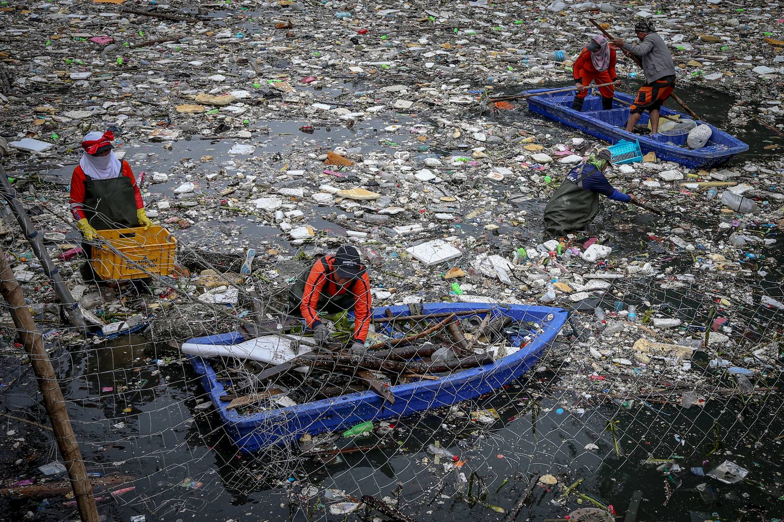 Personnel work through the rain to clear a massive buildup of garbage from the Redemptorist Water Channel in Parañaque City on Tuesday afternoon, 11 August. | Aram Lascano