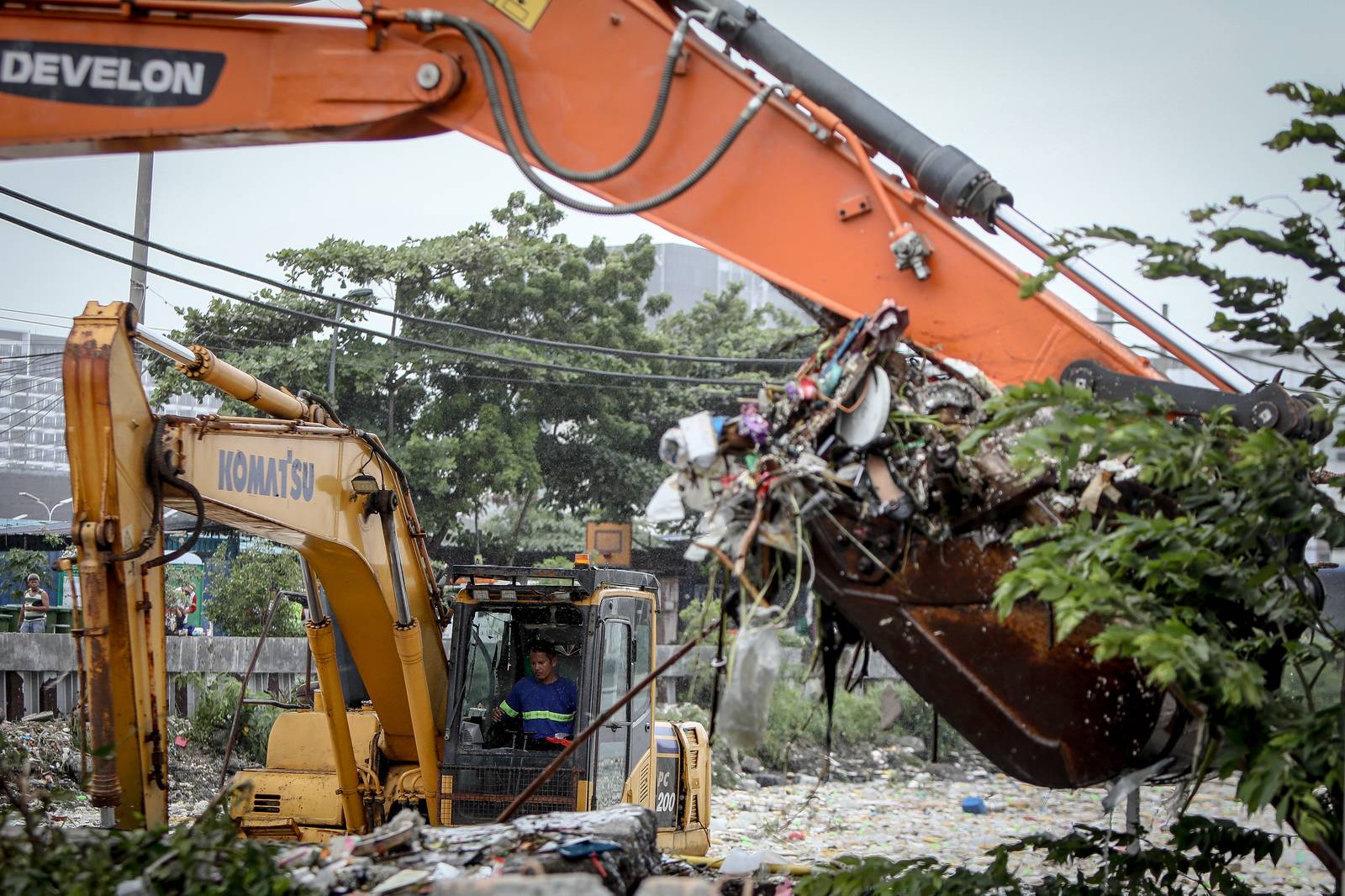 Personnel work through the rain to clear a massive buildup of garbage from the Redemptorist Water Channel in Parañaque City on Tuesday afternoon, 11 August. | Aram Lascano