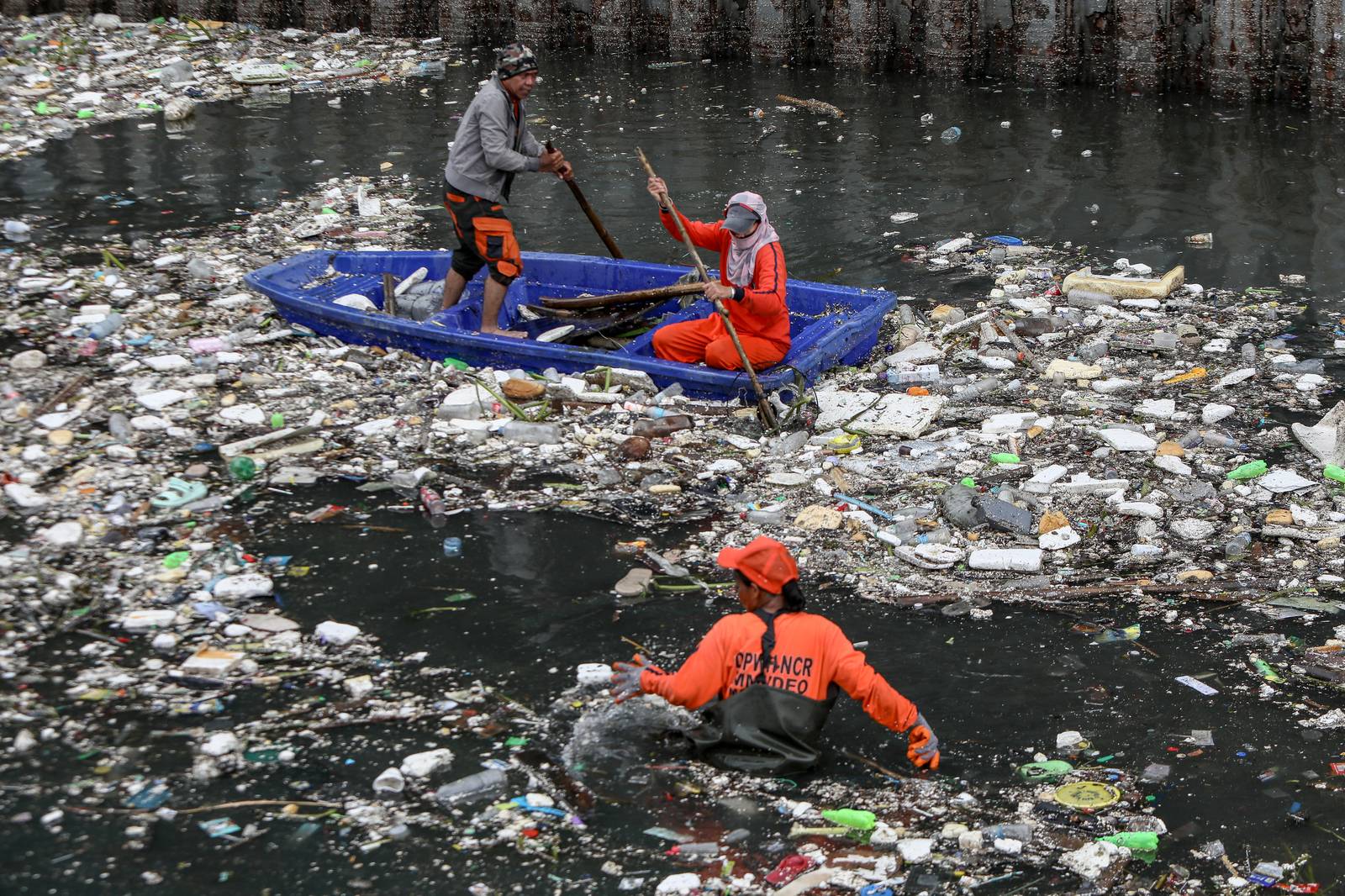 Personnel work through the rain to clear a massive buildup of garbage from the Redemptorist Water Channel in Parañaque City on Tuesday afternoon, 11 August. | Aram Lascano