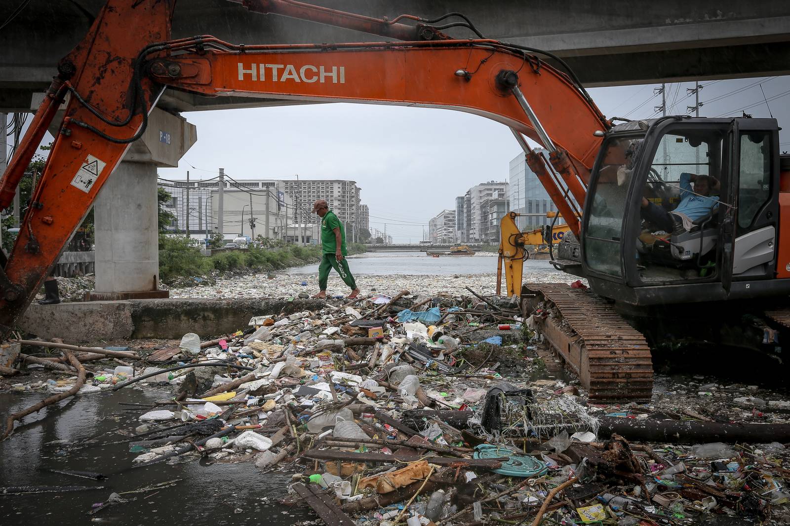 Personnel work through the rain to clear a massive buildup of garbage from the Redemptorist Water Channel in Parañaque City on Tuesday afternoon, 11 August. | Aram Lascano
