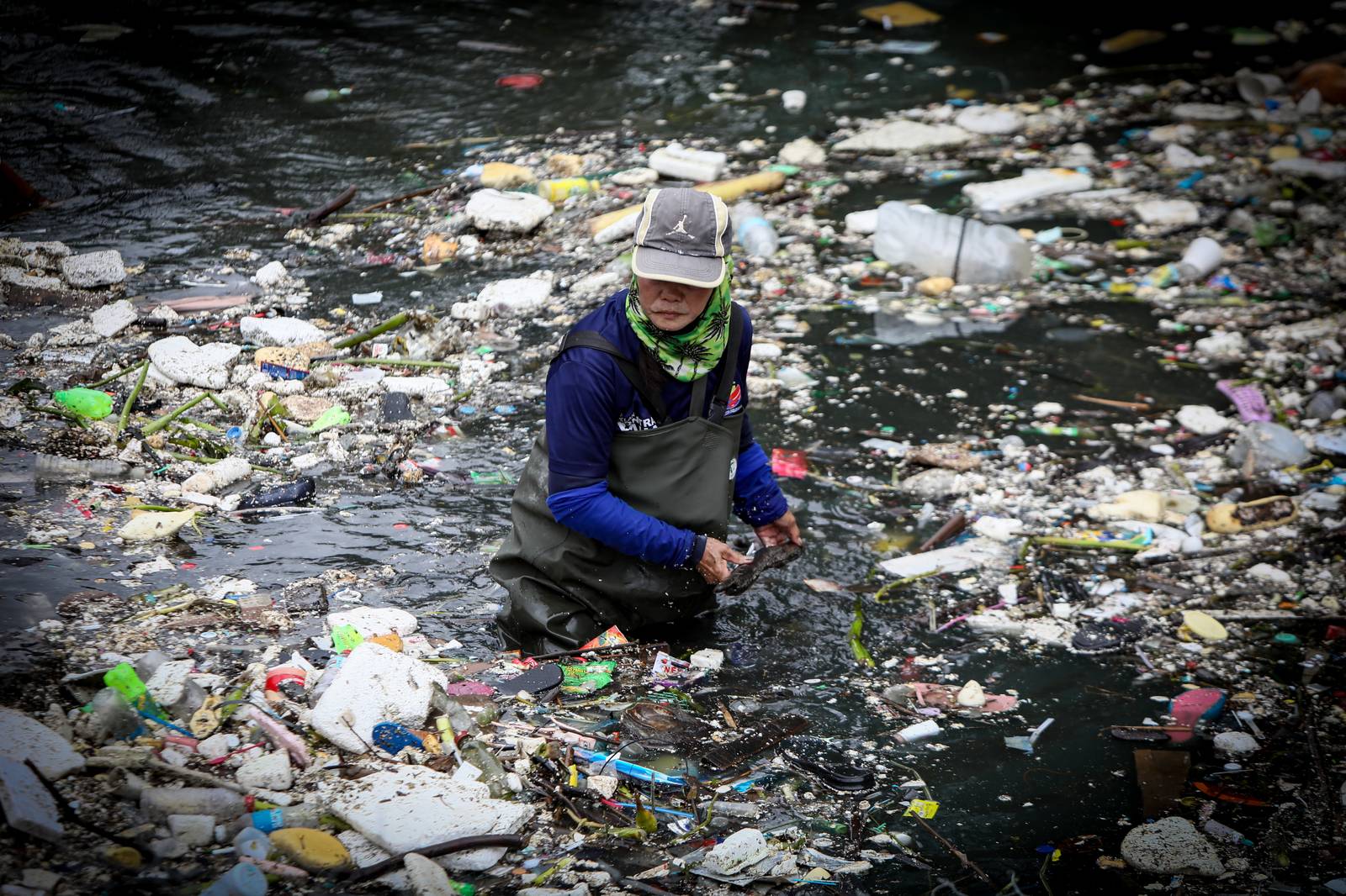 Personnel work through the rain to clear a massive buildup of garbage from the Redemptorist Water Channel in Parañaque City on Tuesday afternoon, 11 August. | Aram Lascano
