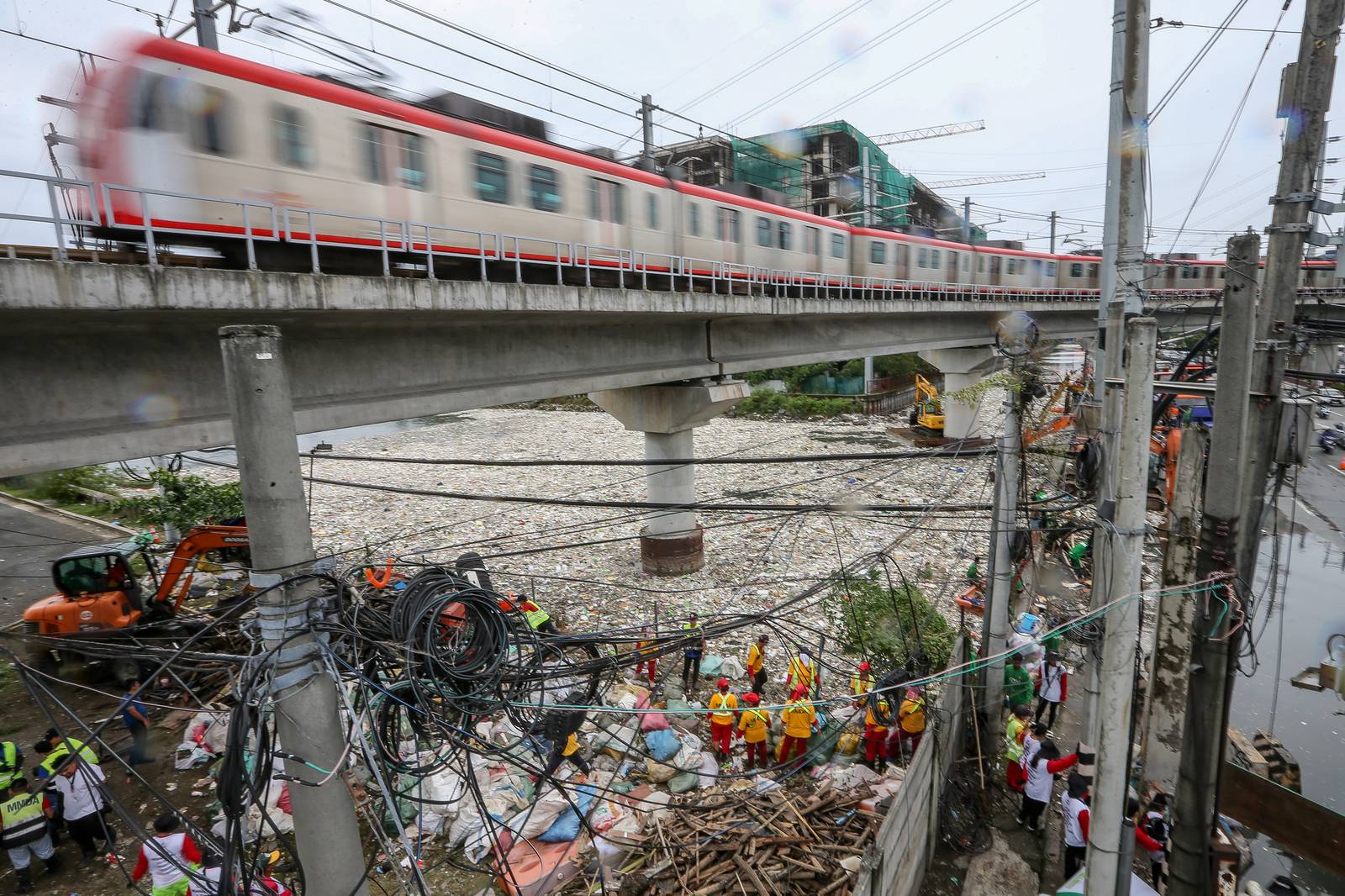Personnel work through the rain to clear a massive buildup of garbage from the Redemptorist Water Channel in Parañaque City on Tuesday afternoon, 11 August. | Aram Lascano