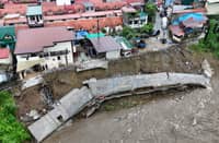 RESIDENTS observe the damage to a P5-million river wall in Barangay Prenza II, Marilao, Bulacan, on Wednesday, a day after heavy rains from the enhanced southwest monsoon caused it to collapse.
