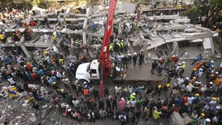 Rescuers and volunteers search for survivors amid the rubble of a collapsed building after an earthquake in Cali, Colombia on August 11, 2026. Colombian volunteers and rescuers cleared rubble with their bare hands to search for survivors early on August 11 after the country's strongest earthquake in a decade killed at least 169 people and smashed dozens of buildings.