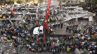 Rescuers and volunteers search for survivors amid the rubble of a collapsed building after an earthquake in Cali, Colombia on August 11, 2026. Colombian volunteers and rescuers cleared rubble with their bare hands to search for survivors early on August 11 after the country's strongest earthquake in a decade killed at least 169 people and smashed dozens of buildings.