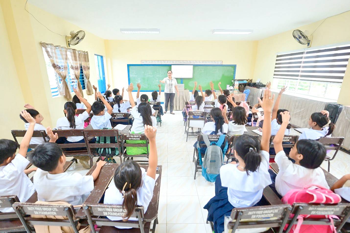 Students eagerly raise their hands to answer a question during one of their math lectures.