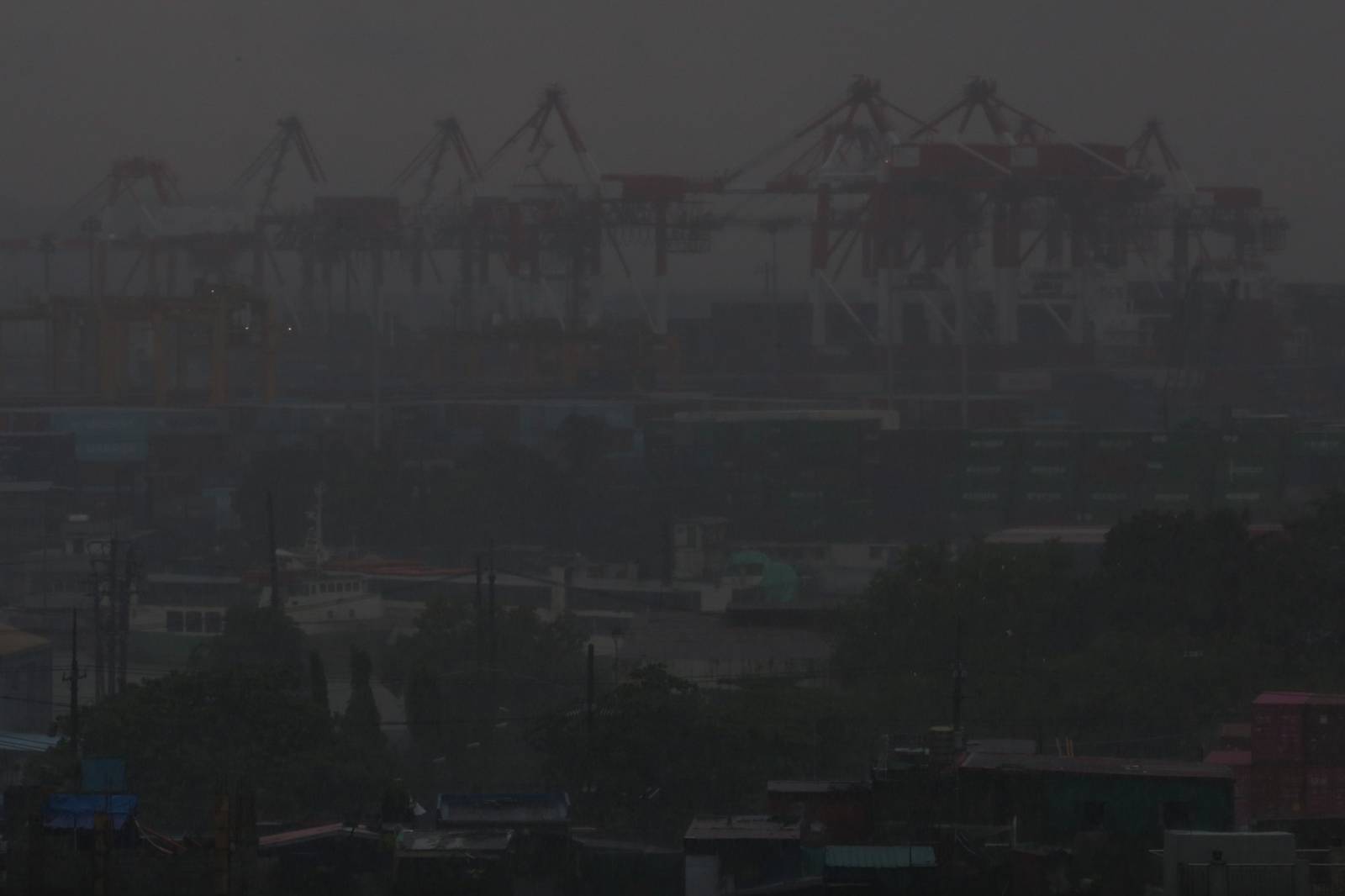 Heavy rain brought by the southwest monsoon, or habagat, reduces visibility over the port area in Manila on 14 August 2026, as seen from the Joaquin Domagoso Gymnasium. The state weather bureau PAGASA issued an Orange Rainfall Warning at 10:20 a.m.