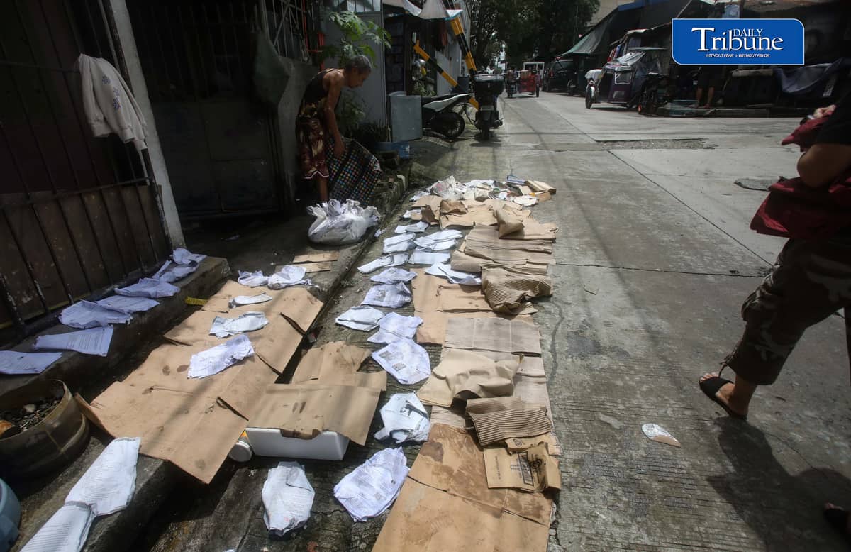 (August 15 2026) A man was seen spreading wet paper and boxes for drying outside his house in Caloocan City, to take advantage when the sun appeared, on Saturday morning August 15 2026. Photo/Analy Labor