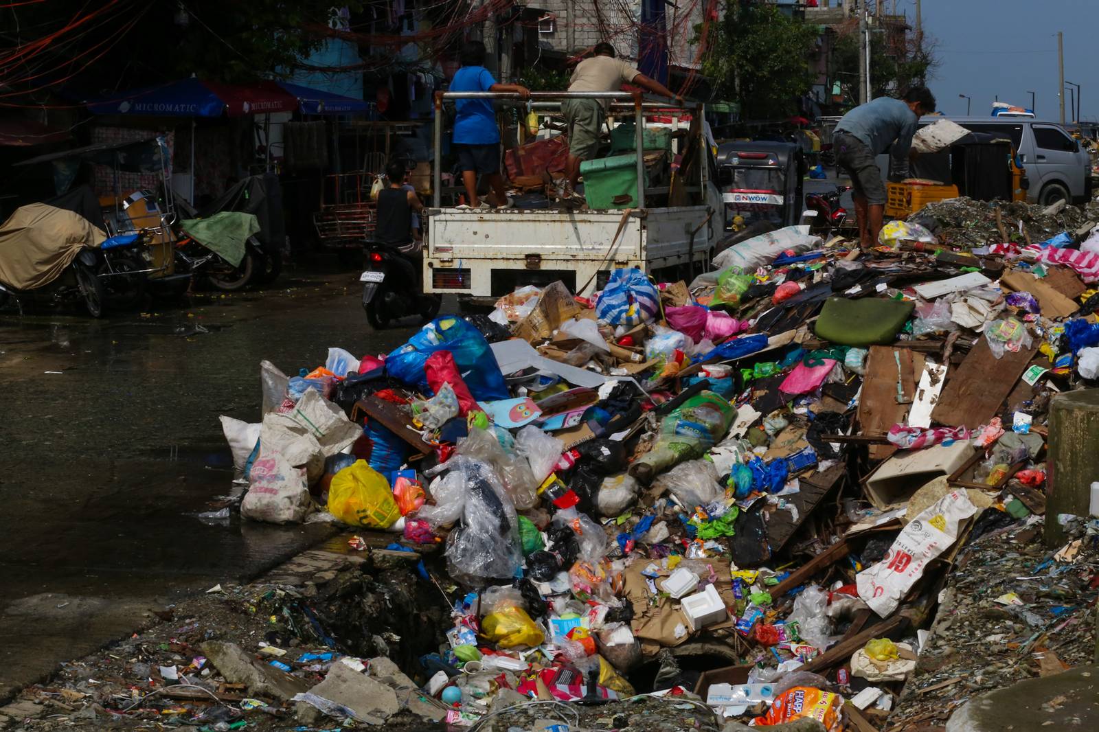 Barangay personnel collect trash and debris dumped along a seawall in Baseco, Manila, on 15 August 2026. According to the DENR, the Philippines generates up to 65,000 tons of waste daily, with nearly half going uncollected and contributing to pollution in streets and waterways.