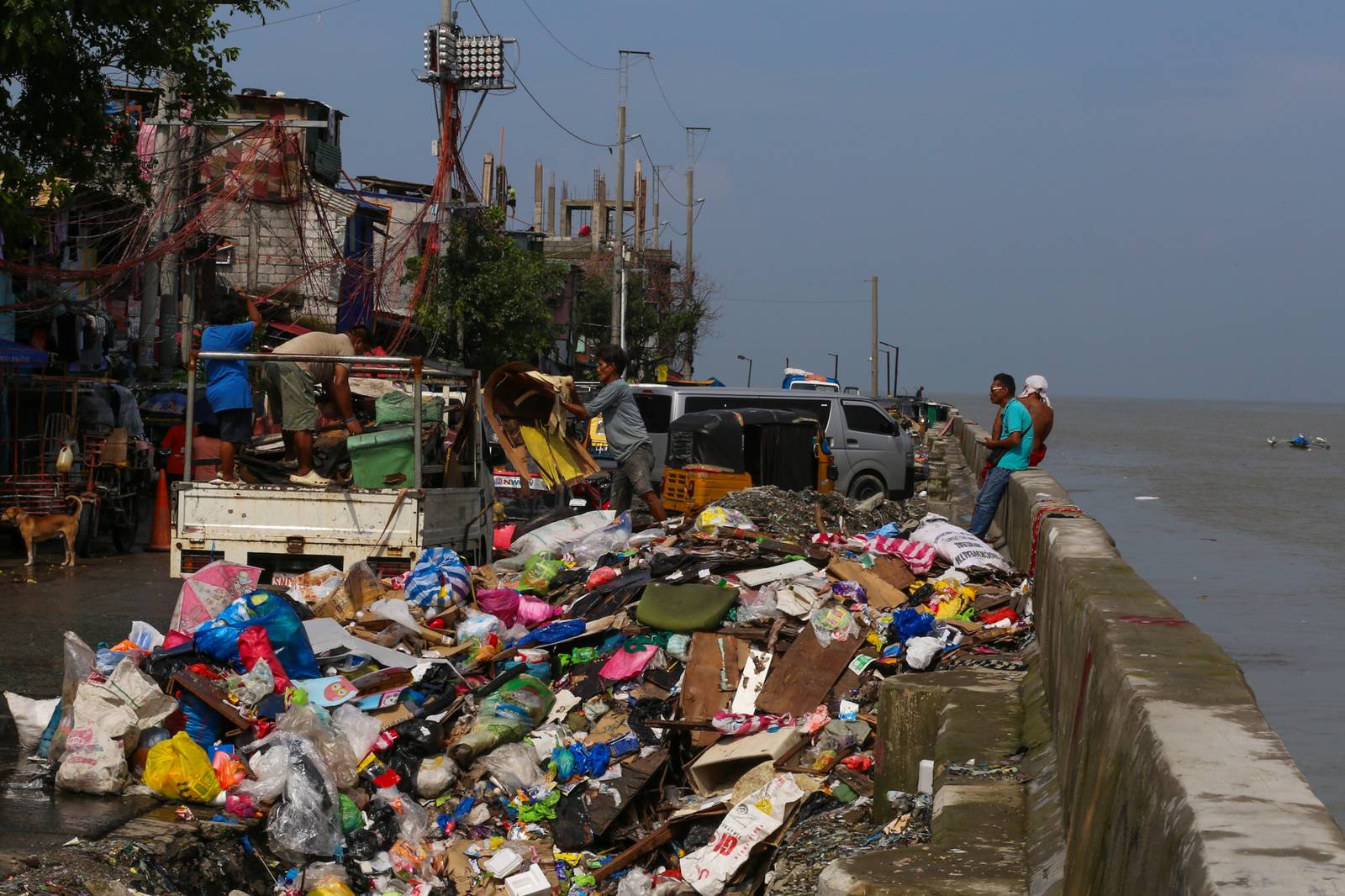 Barangay personnel collect trash and debris dumped along a seawall in Baseco, Manila, on 15 August 2026. According to the DENR, the Philippines generates up to 65,000 tons of waste daily, with nearly half going uncollected and contributing to pollution in streets and waterways.