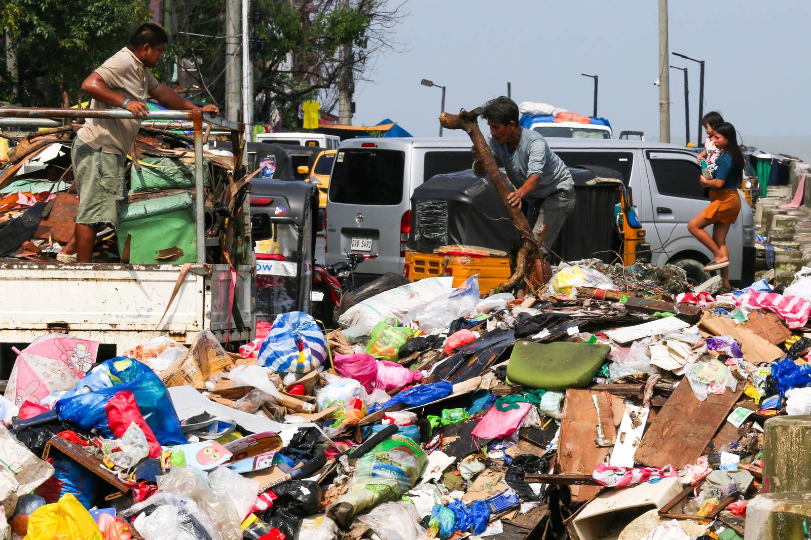 Barangay personnel collect trash and debris dumped along a seawall in Baseco, Manila, on 15 August 2026. According to the DENR, the Philippines generates up to 65,000 tons of waste daily, with nearly half going uncollected and contributing to pollution in streets and waterways.