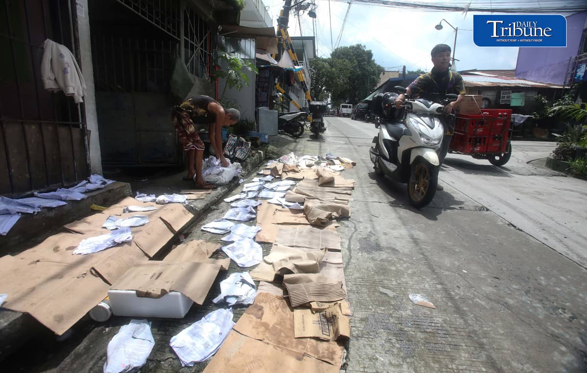 (August 15 2026) A man was seen spreading wet paper and boxes for drying outside his house in Caloocan City, to take advantage when the sun appeared, on Saturday morning August 15 2026. Photo/Analy Labor