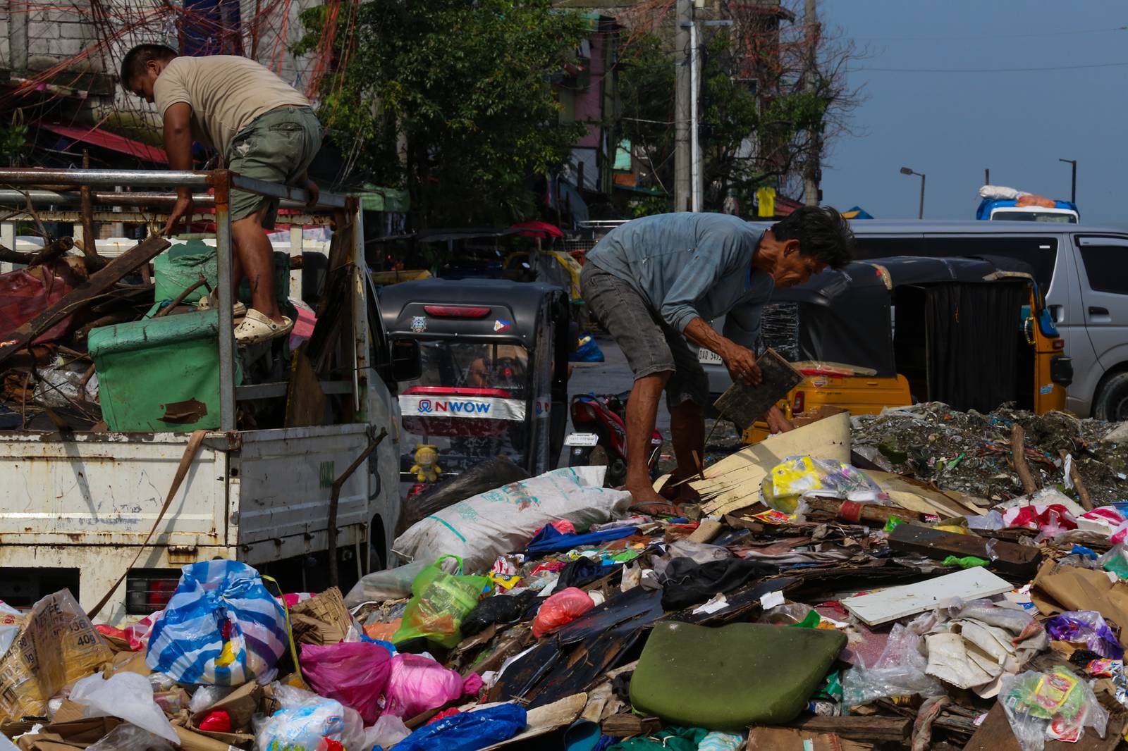 Barangay personnel collect trash and debris dumped along a seawall in Baseco, Manila, on 15 August 2026. According to the DENR, the Philippines generates up to 65,000 tons of waste daily, with nearly half going uncollected and contributing to pollution in streets and waterways.