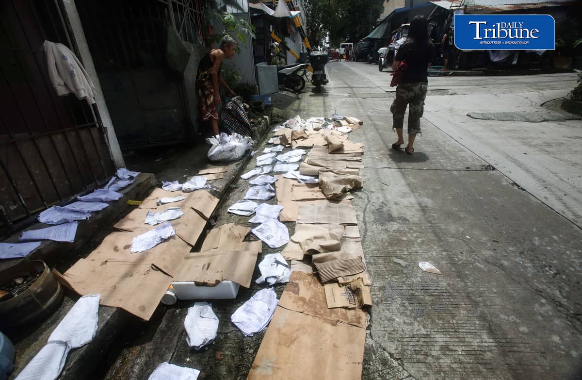(August 15 2026) A man was seen spreading wet paper and boxes for drying outside his house in Caloocan City, to take advantage when the sun appeared, on Saturday morning August 15 2026. Photo/Analy Labor