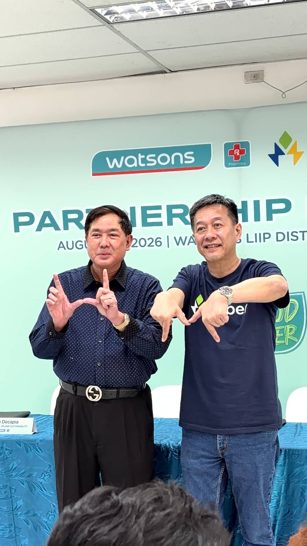 Chiong and Ng make the W and M signs, representing Watsons and Mober, respectively.