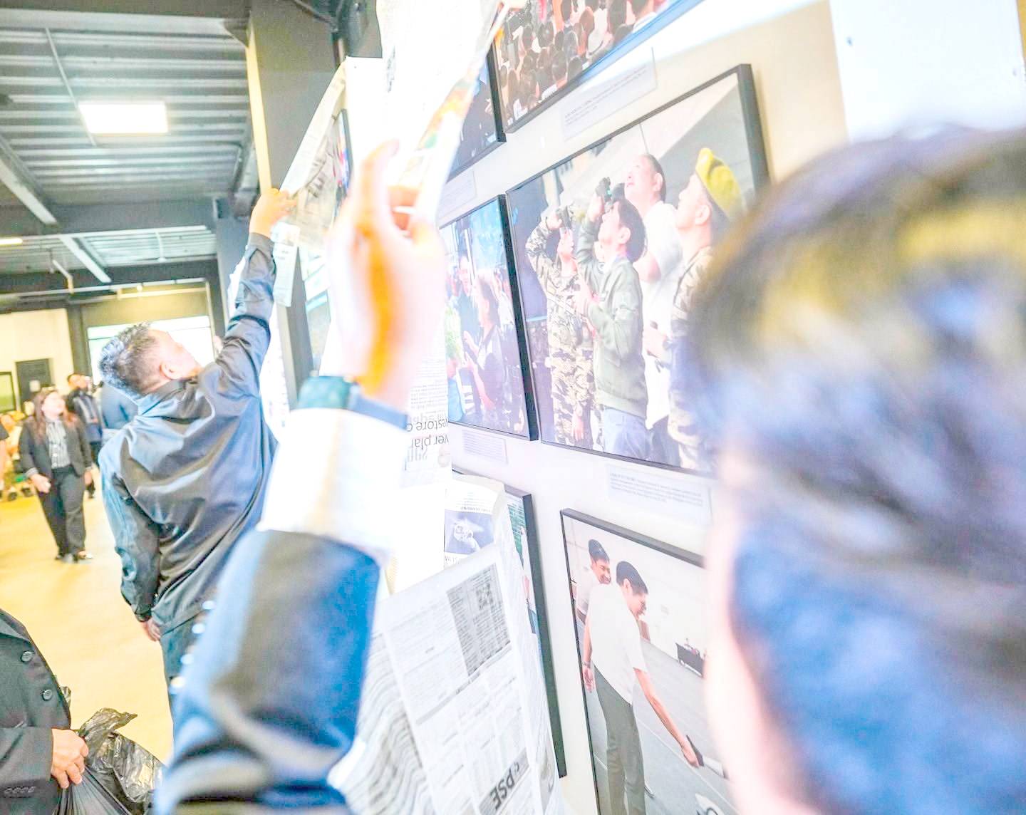 Visitors browse photographs on display.