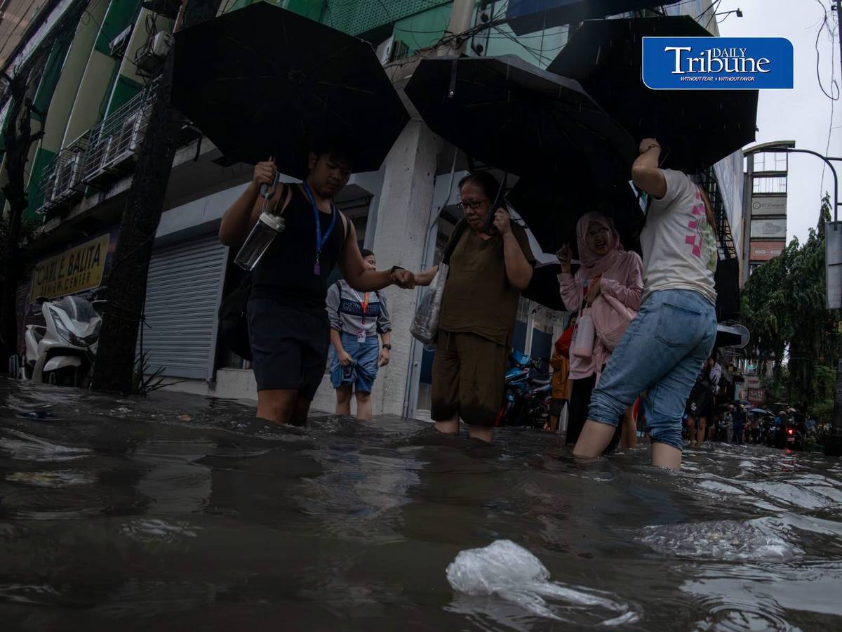 Commuters wade through deep floodwaters in Manila as torrential rains driven by the enhanced southwest monsoon (habagat).