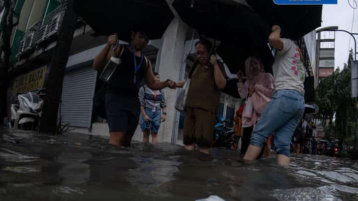 Commuters wade through deep floodwaters in Manila as torrential rains driven by the enhanced southwest monsoon (habagat).