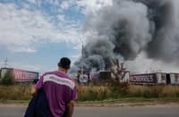 Wildberries employee watches a plume of smoke rise during a fire at the Russian e-commerce firm’s logistics complex near Podolsk, outside Moscow
