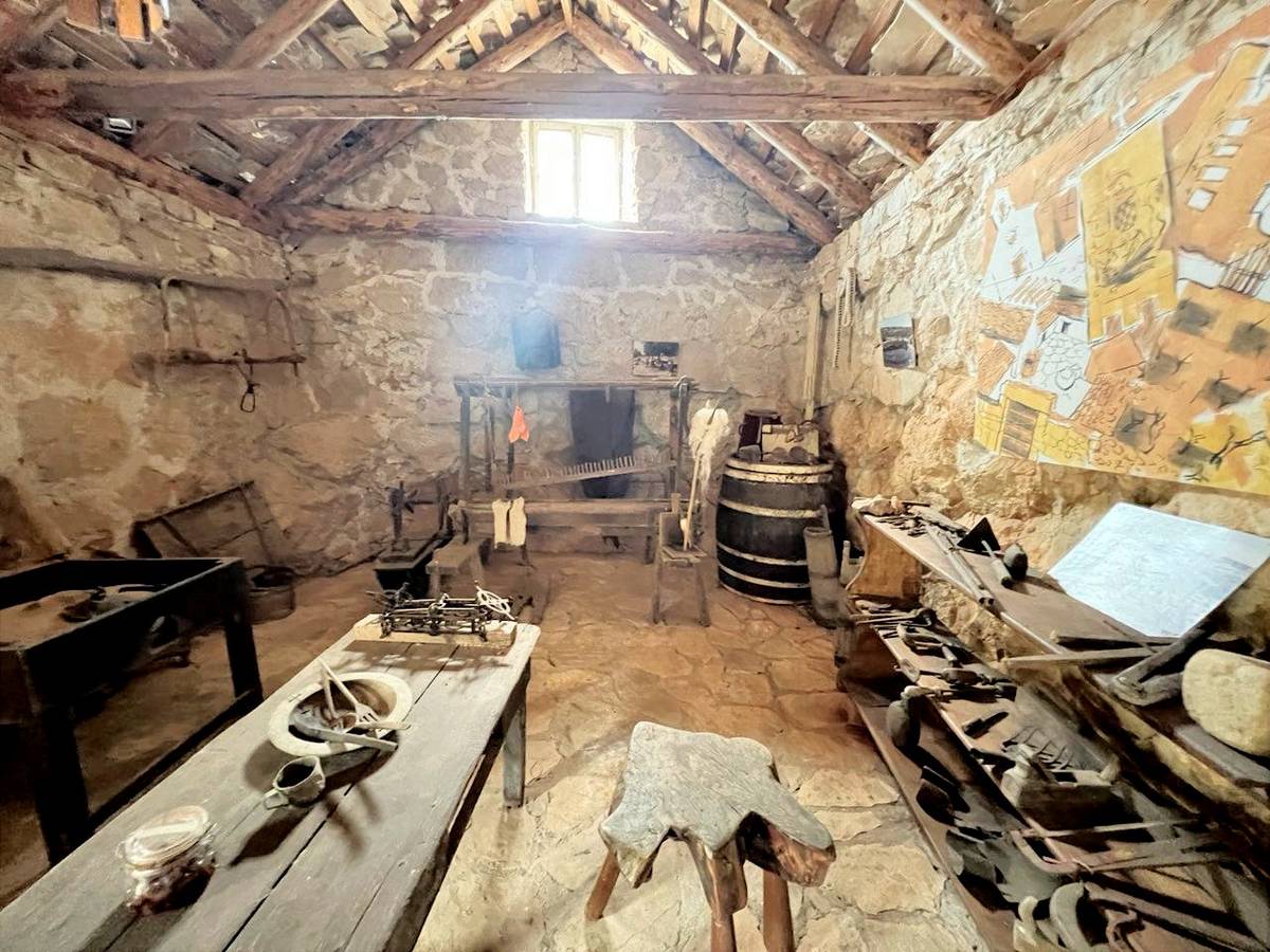 A well-equipped rustic kitchen with aged tools of long ago.