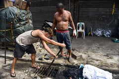 Vendors declogging a drain in Quiapo