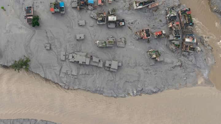 Mudman Nepal Army personnel rescue a man (inset) stranded by massive floods and landslides along the Nepal-Tibet border on 26 August 2026. The disaster killed nearly 200 people and left hundreds missing from the mud- and water-swept banks of rivers (main panel).