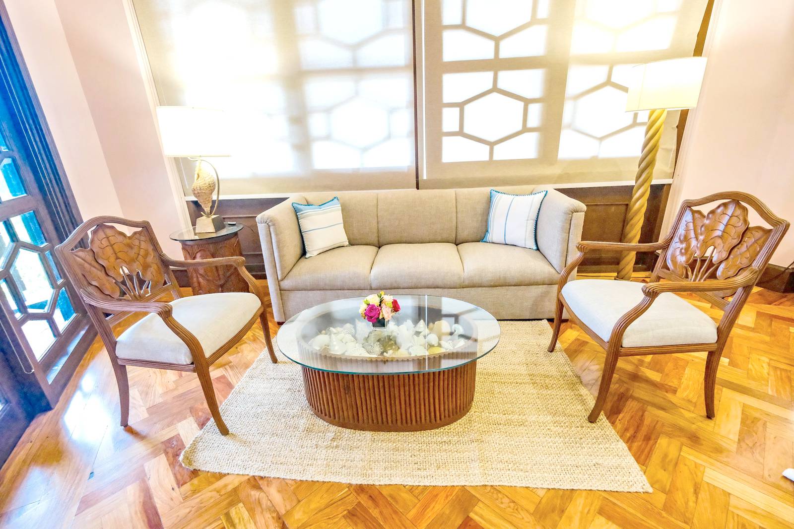 CLASSIC neutral-toned upholstered loveseat accented with two ivory throw pillows in the Pampanga Room.