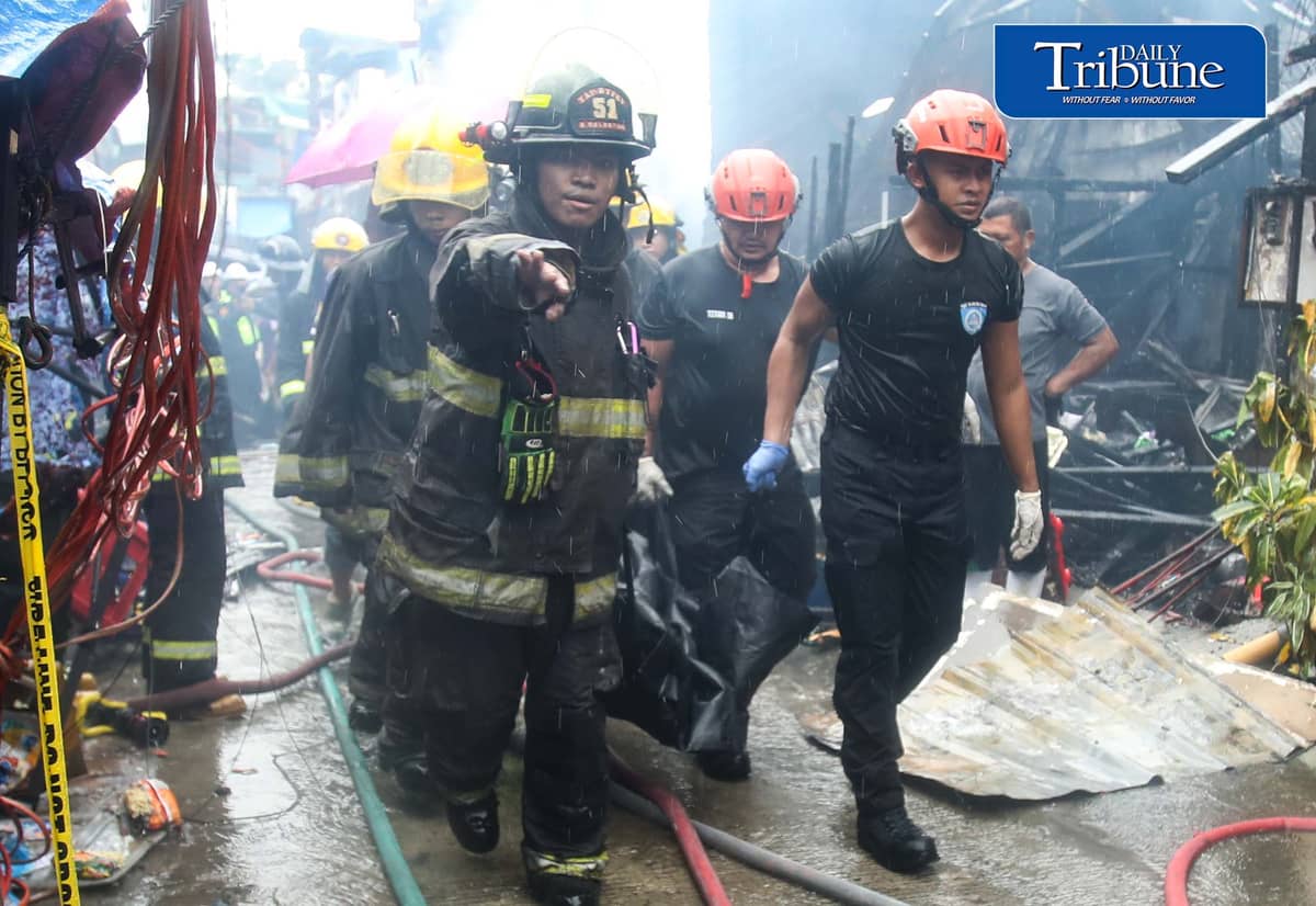 (August 28 2026) Authorities carrying the body bag loaded of a lifeless woman killed by the fire, at 13th Street in Damayang Lagi, Quezon City, on Friday, August 28, 2026. According to the residents a woman entered their house again to look for her mother, but unfortunately she was able to come out again, and authorities found her dead. Photo/Analy Labor