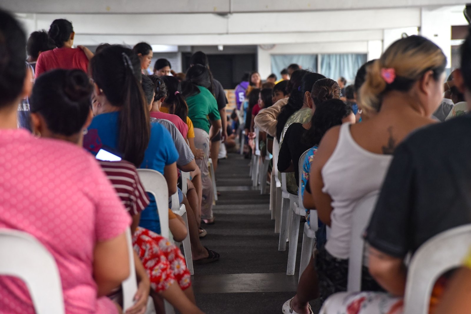 Families displaced by the effects of the southwest monsoon receive hot meals prepared by Manila Department of Social Welfare personnel at the Don Bosco Evacuation Center in Sta. Mesa, Manila, on August 30. The center is sheltering 515 evacuees. l Zedrich Xylak Madrid