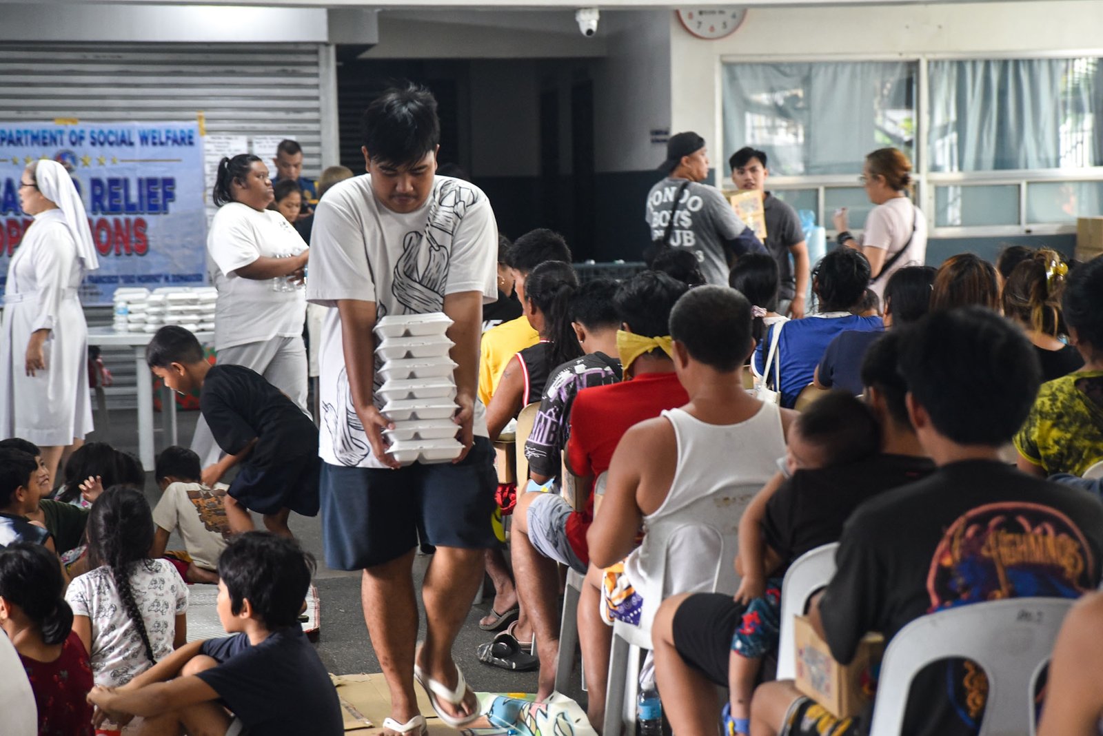 Families displaced by the effects of the southwest monsoon receive hot meals prepared by Manila Department of Social Welfare personnel at the Don Bosco Evacuation Center in Sta. Mesa, Manila, on August 30. The center is sheltering 515 evacuees. l Zedrich Xylak Madrid