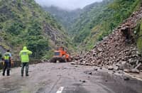 Department of Public Works and Highways personnel clear debris along Kennon Road in Tuba, Benguet. Motorists and residents are urged to exercise extreme caution when traveling through the area.