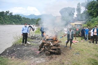 Morgues overflow, burials begin