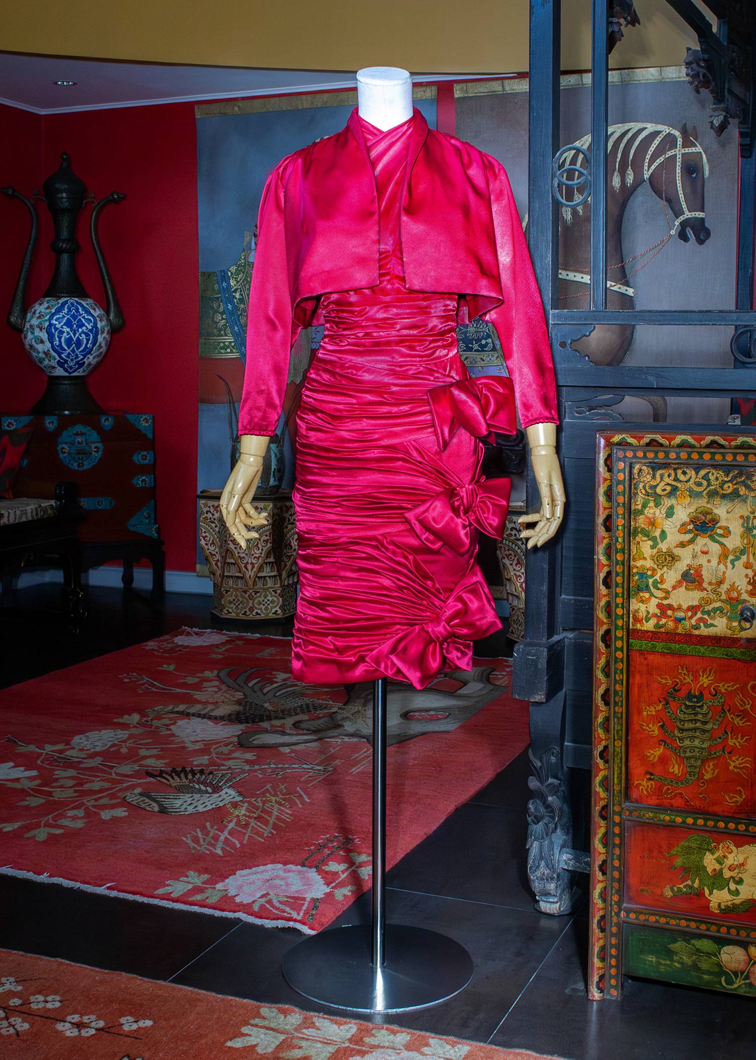 Fuchsia-pink satin ensemble featuring a ruched dress with bow appliqués.
