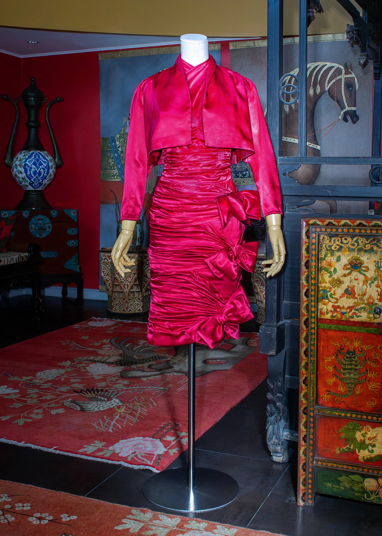 Fuchsia-pink satin ensemble featuring a ruched dress with bow appliqués.