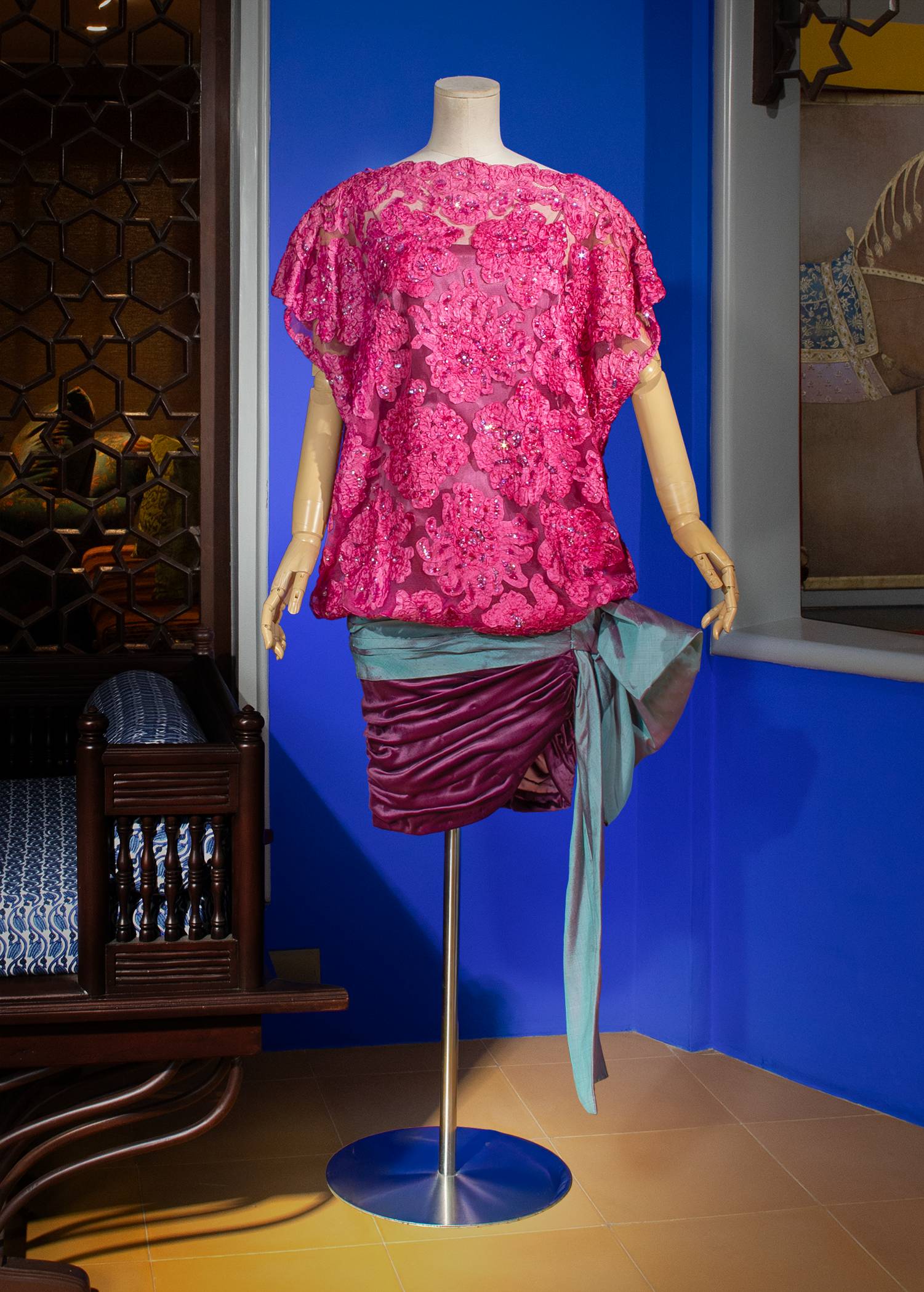 Magenta-colored Dognin lace mini dress with a deep plum ruched velour skirt draped with an iridescent Thai silk bow.