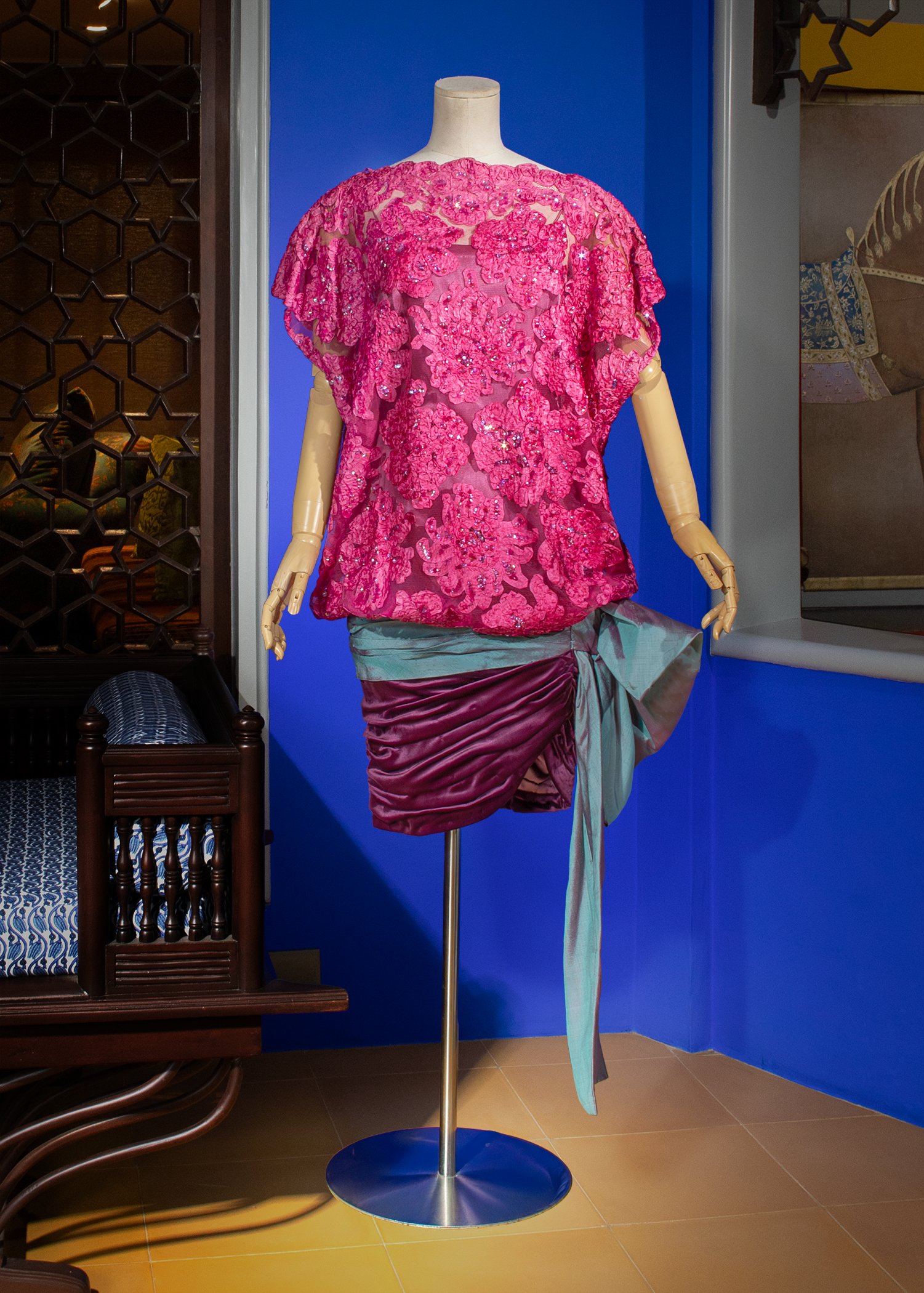 Magenta-colored Dognin lace mini dress with a deep plum ruched velour skirt draped with an iridescent Thai silk bow.