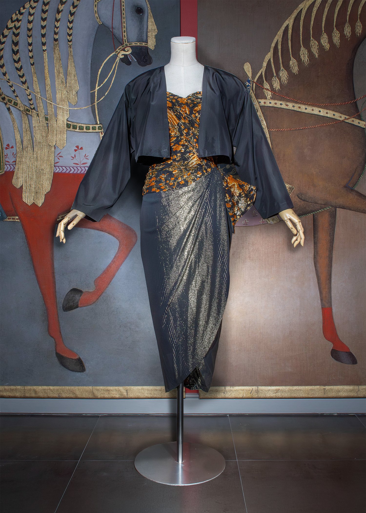 Strapless dress with a black silk chiffon bodice featuring an orange velvet floral motif with metallic gold pile, overlaid with a draped sarong in black georgette with lurex, paired with a boxy cropped black taffeta jacket.