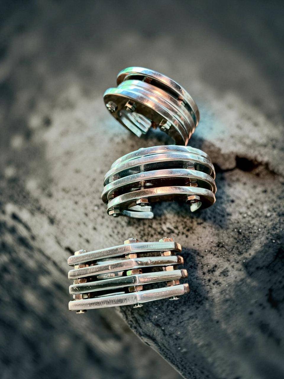 hefty industrial cuff is created from thin aluminum shapes held together with classic stainless screws and bolts.