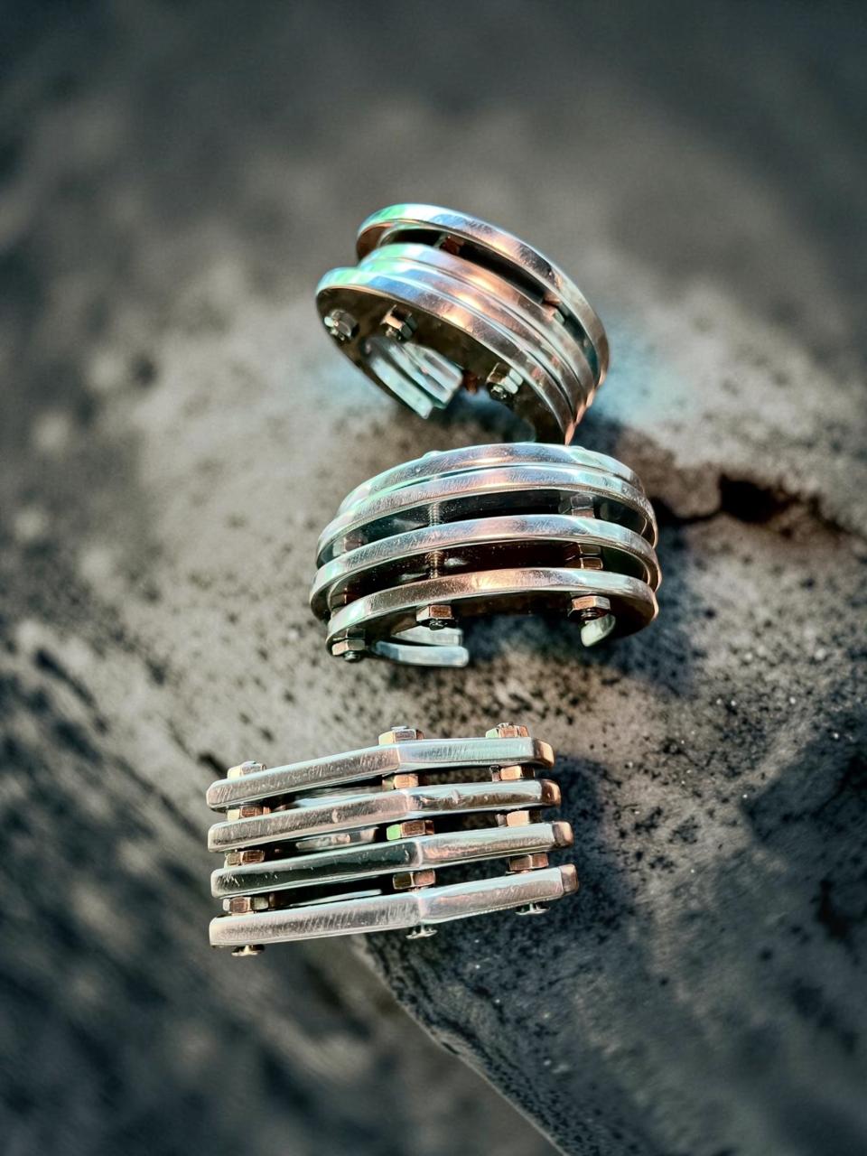 hefty industrial cuff is created from thin aluminum shapes held together with classic stainless screws and bolts.
