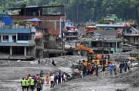 RESCUERS clear mud and debris Monday, six days after glacial floods swept Nepal, Tibet and India, leaving at least 939 people dead and nearly 4,500 missing.