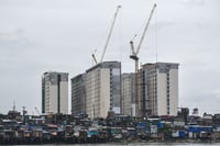 High rise building looms an informal settlement amid PH Triillion Debt