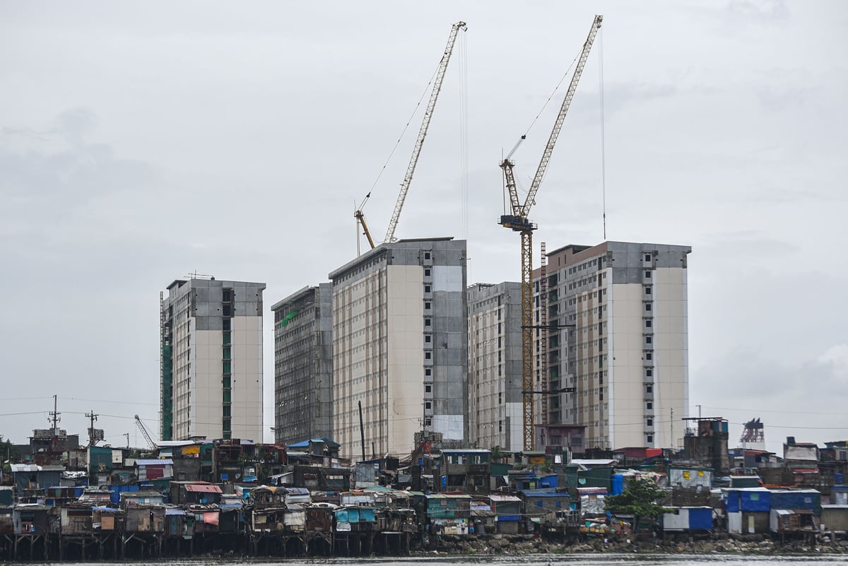 High rise building looms an informal settlement amid PH Triillion Debt