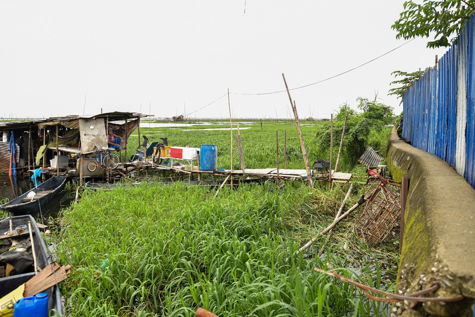 Fisherman Eddy Casin, 46, stands near his makeshift home beside the Lakeshore Complex in Taguig City on 5 September. Casin said the nearby reclamation project has hurt his livelihood, making it harder to earn from fishing and meet his daily needs. | Zedrich Xylak Madrid