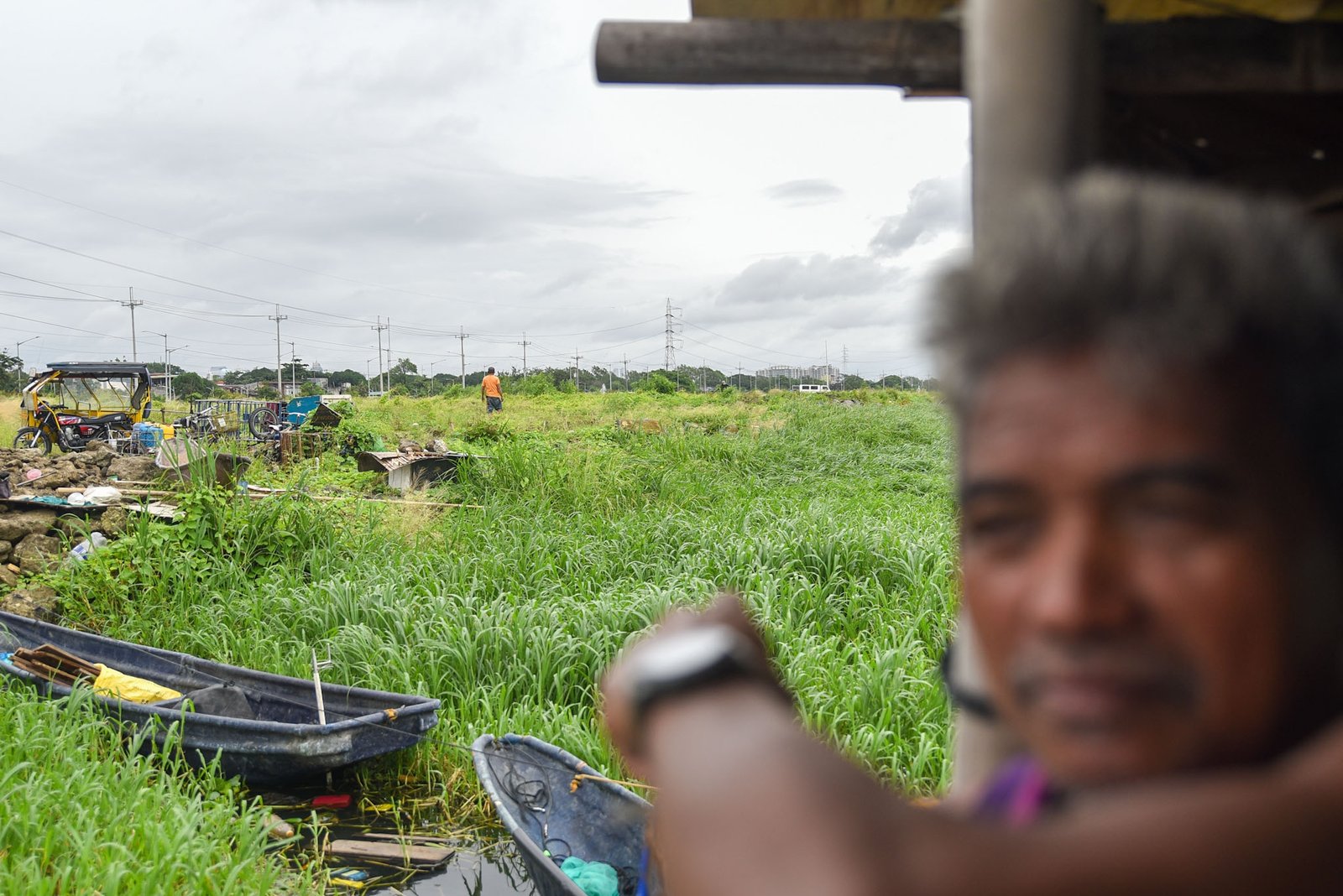Fisherman Eddy Casin, 46, stands near his makeshift home beside the Lakeshore Complex in Taguig City on 5 September. Casin said the nearby reclamation project has hurt his livelihood, making it harder to earn from fishing and meet his daily needs. | Zedrich Xylak Madrid