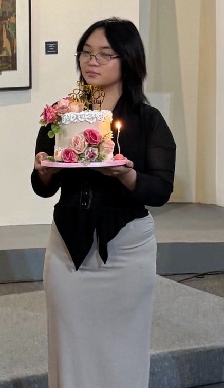 A YSPACE Officer presents a birthday cake to the star of the evening.