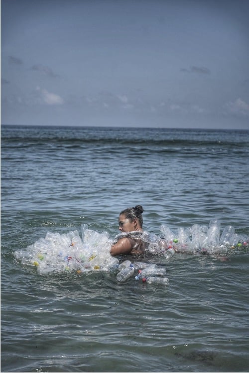 Bari-Bari film still, with a dancer surrounded by plastic bottles in the sea.
