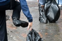 Commuters wear trash bags as makeshift protection