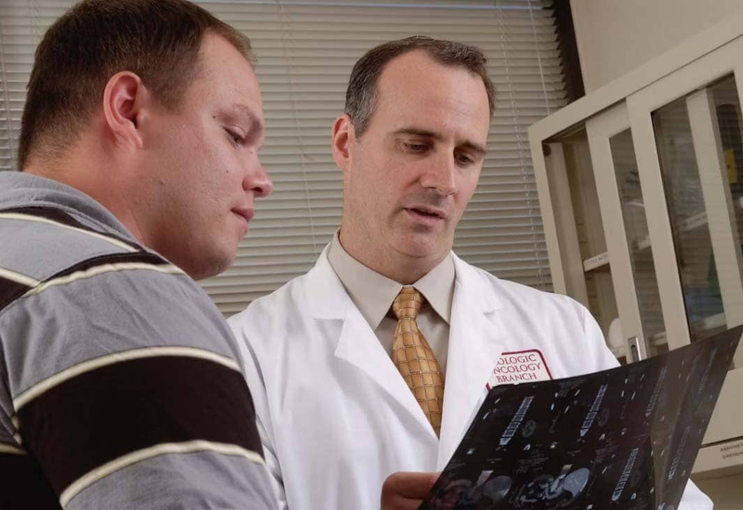 HEALTHCARE provider discusses a medical scan with a patient, highlighting the importance of family support throughout their healthcare journey.