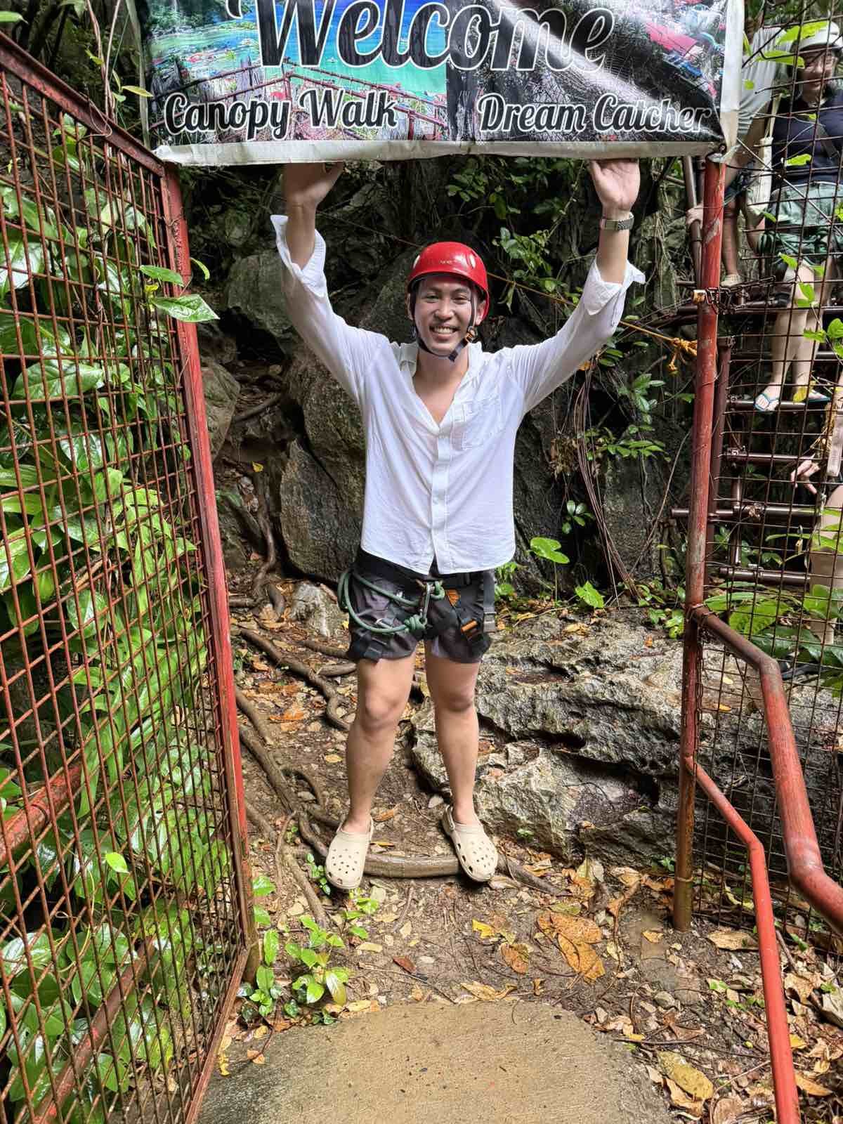 DAILY TRIBUNE reporter Mico Virata (above) stands at the entrance of the canopy walk in El Nido, Palawan, wearing a safety helmet and harness. Virata and other reporters (below) pose with DMCI employees at the ‘Spider Web’ viewing platform of the El Nido Via Ferrata Canopy Walk on Taraw Cliff.